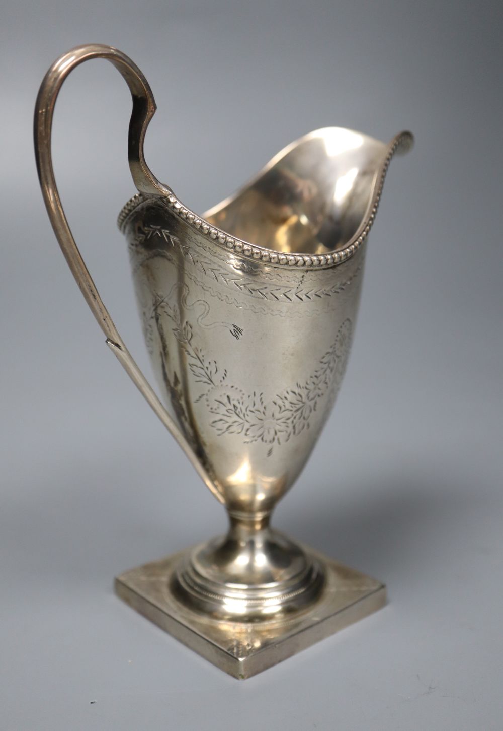 A George III engraved silver helmet shaped cream jug by Hester Bateman, London, 1785, 14.9cm, 4.5oz,